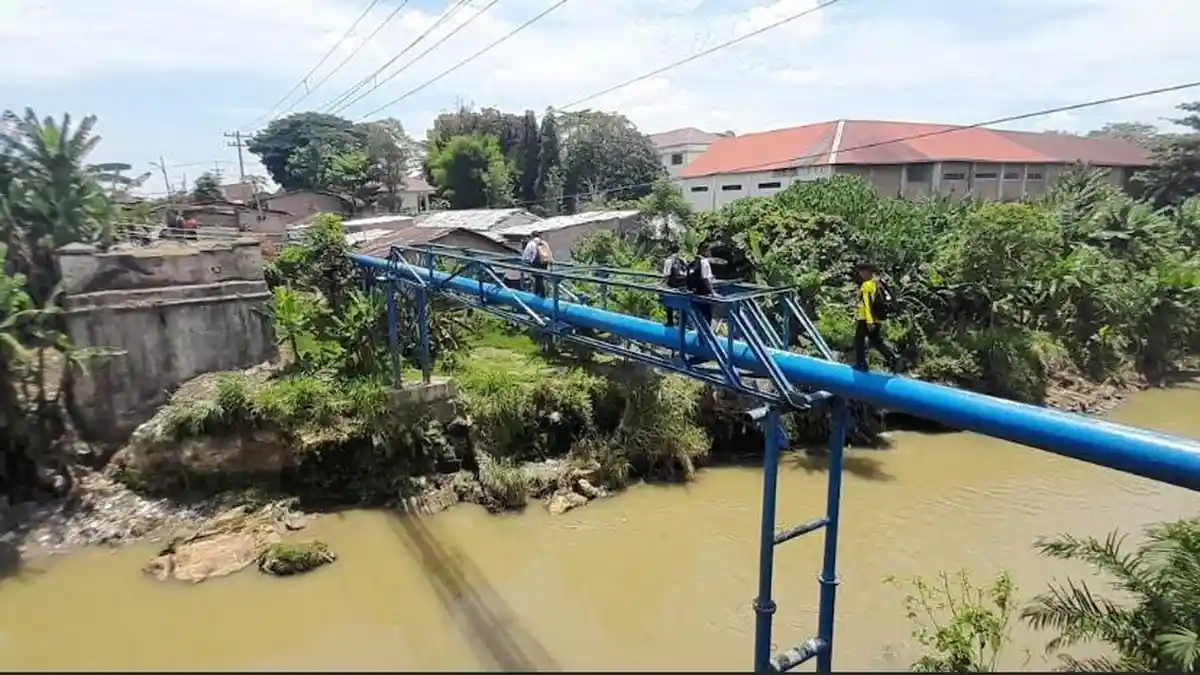 Sejumlah-pelajar-melintas-di-pipa-PDAM-yang-berada-di-atas-aliran-Sungai-Deli-1